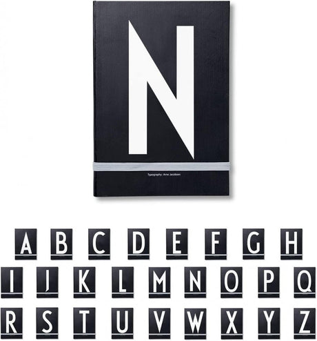 Design Letters A-Z Fekete Notizbuch, A5 Méretű, Keményfedelű Jegyzetfüzet Rugalmas Zárószalaggal - Outlet24